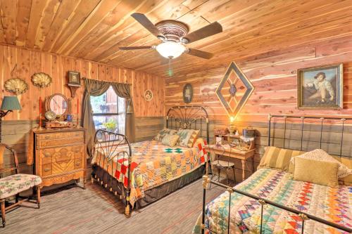 - une chambre avec 2 lits et un ventilateur de plafond dans l'établissement Quiet, Historic Manor Located in Ghost Town!, à Calico Rock