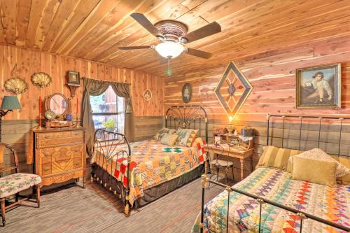 a bedroom with two beds and a ceiling fan at Quiet, Historic Manor Located in Ghost Town! in Calico Rock