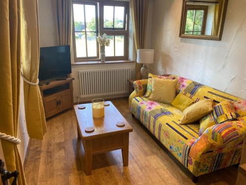 uma sala de estar com um sofá e uma mesa de centro em Character 1 bedroom country annex in West Camel em Yeovil