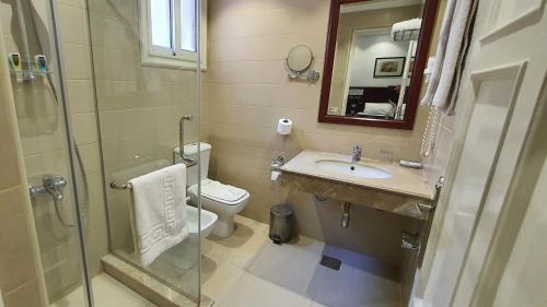 a bathroom with a toilet and a sink and a shower at Horus House Hotel Zamalek in Cairo