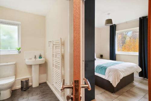 a bathroom with a bed and a sink and a toilet at Peaceful 2BR Flat with Historic Bottle Kilns View & Free Parking Located near City Centre in Stoke on Trent