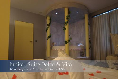 Schlafzimmer mit einem Spiegel mit einer Badewanne und einem Bett in der Unterkunft Hotel Herberge in Teufenthal