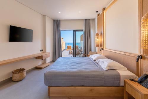 a hotel room with a bed and a television at Bali Star Resort Hotel in Balíon