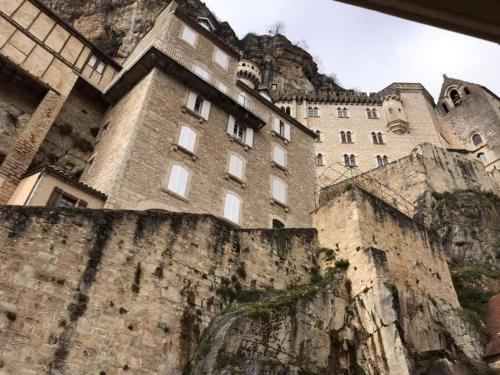 un bâtiment sur le côté d'une montagne dans l'établissement Chalet avec vue imprenable, à Rocamadour