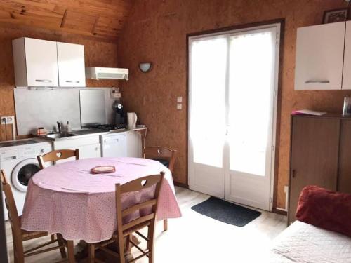 a kitchen with a table with a pink table cloth at Chalet avec vue imprenable in Rocamadour