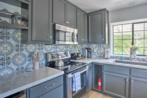 a kitchen with blue cabinets and a stove top oven at Hilltop Hideaway in Temecula Wine Country in Sage