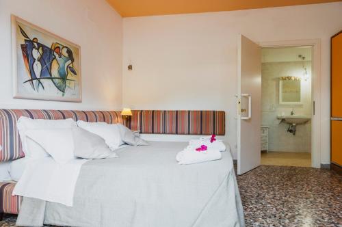 a bedroom with a white bed and a sink at Calliope's Apartments - Stella del Mare in Siracusa