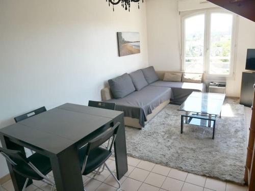 a living room with a couch and a table at Bobigny : 2 pièces proche a86 et commerces in Bobigny