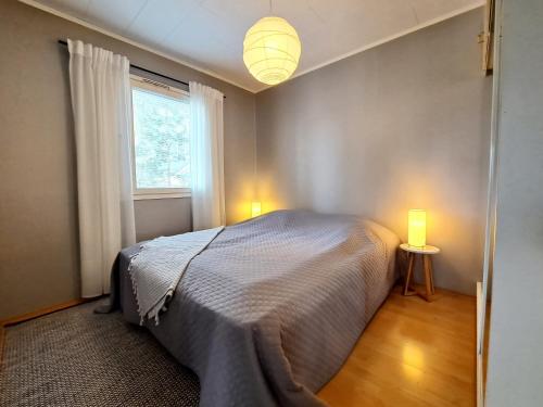 sypialnia z łóżkiem, oknem i 2 lampami w obiekcie Mesiangervo w mieście Kalajoki