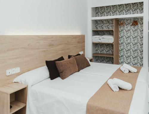 1 dormitorio con 1 cama blanca grande y toallas en Hotel Olive, en Osuna