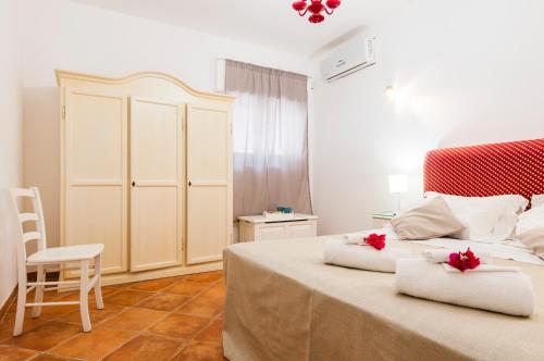 a bedroom with a bed with red flowers on top of it at Calliope's Apartments - Stella del Mare in Siracusa