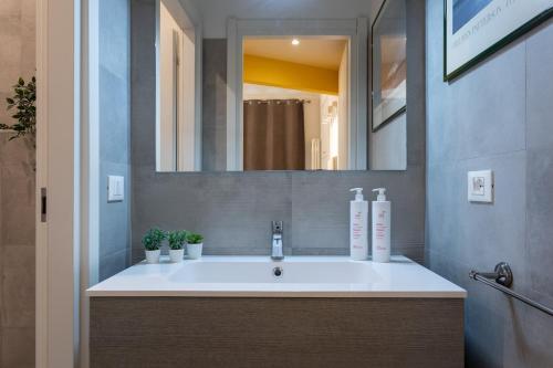 ein Bad mit einem Waschbecken und einem Spiegel in der Unterkunft Porta Susa Studio Apartment by Wonderful Italy in Turin
