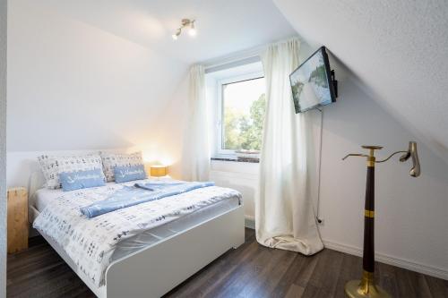 MiBa Mare Ferienwohnung "Stella" في شاربوتس: غرفة نوم بيضاء بها سرير ونافذة