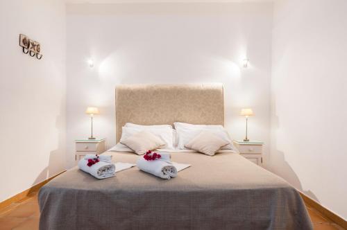 a bedroom with a large bed with two towels on it at Calliope's Apartments - Stella del Mare in Siracusa