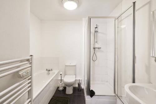a white bathroom with a toilet and a shower at Fully Furnished 2 BR Flat with Free Parking in Stoke on Trent
