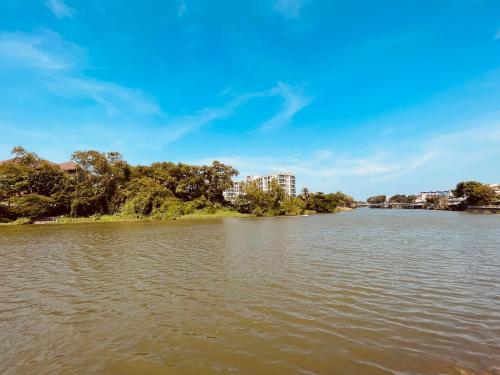 a river with trees and buildings in the distance at USABAI Riverside Boutique Hotel in Chanthaburi