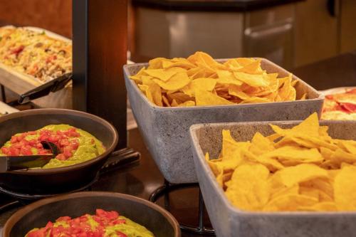 four trays of food and chips on a counter at Sol Palmanova Mallorca in Palmanova