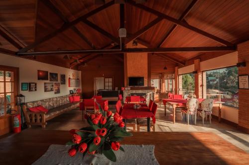 a living room with red chairs and a dining room at Pousada Marco Polo in Campos do Jordão