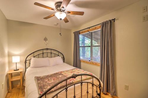 a bedroom with a bed with a ceiling fan and a window at Mountain View Cabin with Wraparound Deck! in Mountain View