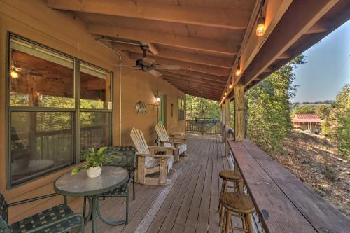 a porch of a house with a table and chairs at Mountain View Cabin with Wraparound Deck! in Mountain View