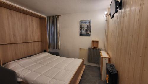 1 dormitorio con 1 cama blanca en una habitación en Studio Le Cérétou - La Mongie Tourmalet, en Bagnères-de-Bigorre