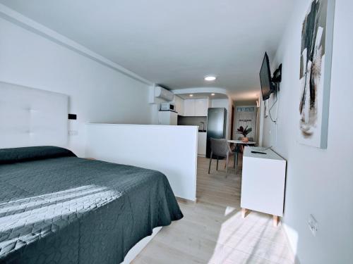 a bedroom with a bed and a kitchen with a table at ESTUDIO DEBORA in Playa Fañabe