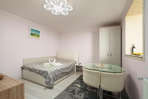 a bedroom with a bed and a glass table at Stone Gate Apartment #1 in Bucharest