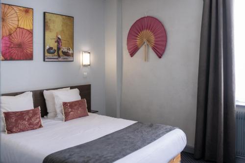 a hotel room with a bed and two umbrellas on the wall at Hotel de Normandie in Lyon