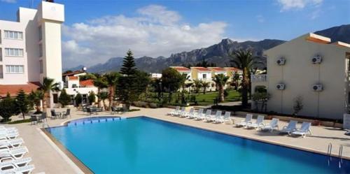 una gran piscina con sillas y un hotel en Mountain View Hotel en Kyrenia