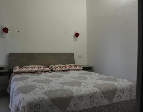 a bedroom with a bed with a comforter and two pillows at Sognando nel borgo in Rocca Imperiale