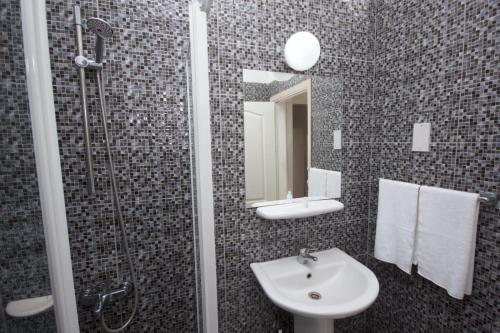 y baño con lavabo y ducha con espejo. en Mountain View Hotel en Kyrenia