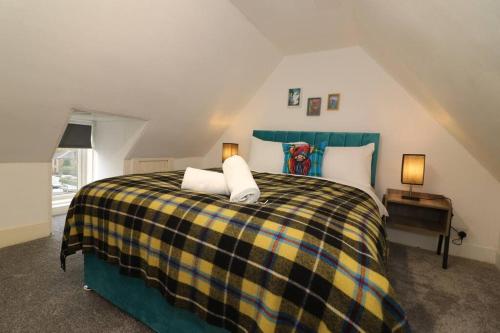 um quarto com uma cama com um cobertor xadrez em 10 Bedrooms Pool Table Garden Piano em Glasgow