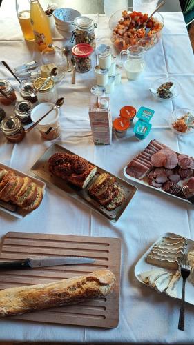 La Maison Forte في Revigny-sur-Ornain: طاولة بيضاء عليها انواع مختلفة من الطعام
