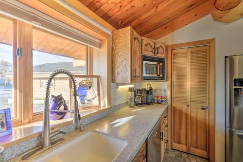 a kitchen with a sink and a window at Fairbanks Log Cabin with Waterfront Deck and Views! in Fairbanks