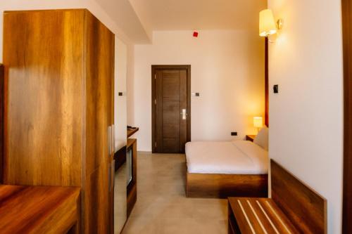 a hotel room with a bed and a door to a bedroom at Cezar's Airport Hotel in North Nicosia