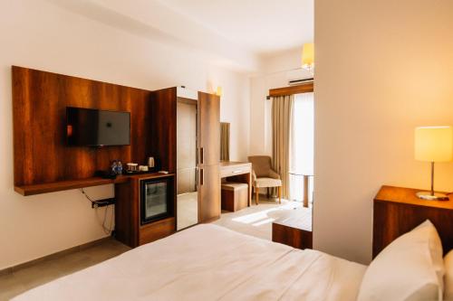 a hotel room with a bed and a flat screen tv at Cezar's Airport Hotel in North Nicosia