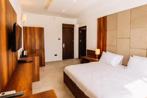 a hotel room with a bed and a television at Cezar's Airport Hotel in North Nicosia