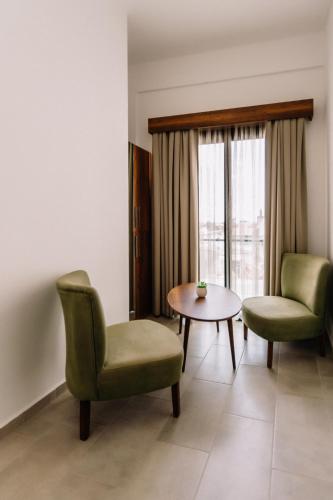 a room with two chairs and a table and a window at Cezar's Airport Hotel in North Nicosia