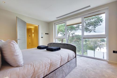 1 dormitorio con 1 cama con 2 almohadas en Luxury 3bd penthouse with roof terrace and hot tub en Canford Cliffs