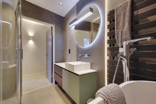 a bathroom with a sink and a mirror at Luxury 3bd penthouse with roof terrace and hot tub in Canford Cliffs
