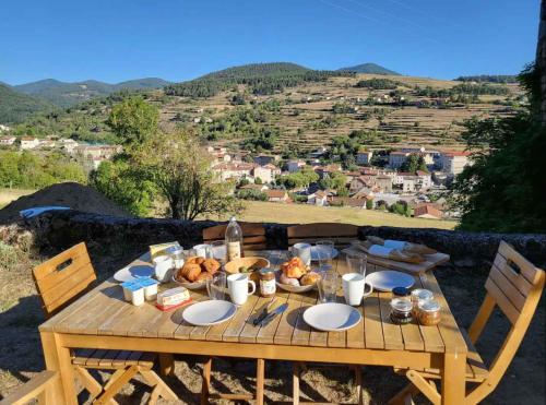 a wooden table with food on it with a view at Le Grenier à Blé in Satillieu
