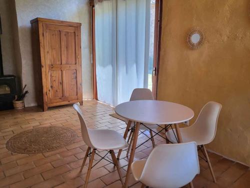 uma mesa e cadeiras num quarto com uma janela em Le Grenier à Blé em Satillieu