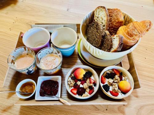 a table with a tray of bread and bowls of food at VillaCanau in Lacanau