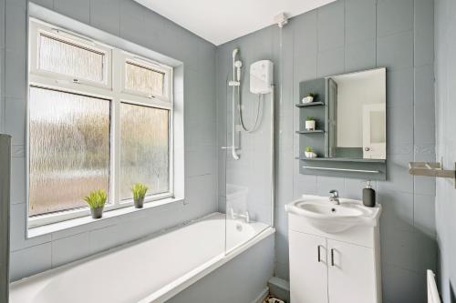 a bathroom with a tub and a sink and a mirror at Stylish 4 Bed House in Nottingham - sleeps 15 in Nottingham