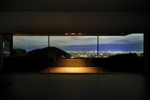 a window with a view of a city at night at Sapporo boukyo Luxury house 5 pax Free Parking in Sapporo