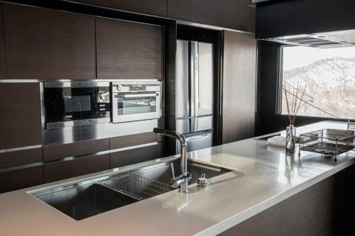 a kitchen counter with a sink and a microwave at Sapporo boukyo Luxury house 5 pax Free Parking in Sapporo