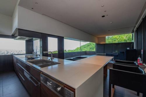 a kitchen with a counter with a sink and some windows at Sapporo boukyo Luxury house 5 pax Free Parking in Sapporo