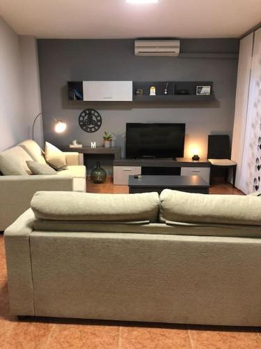 een woonkamer met een bank en een flatscreen-tv bij CHEZ GREDOS in Candeleda