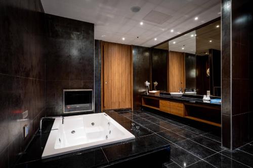 a large bathroom with a tub and a television at Aquarius Motel in Taichung