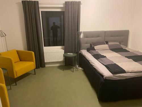 a bedroom with a bed and a yellow chair at Hotell Silverborgen in Sala